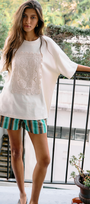 Model wearing a Crochet Detail Oversized T Shirt with crochet applique and scalloped edging, paired with striped shorts.