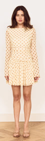 Butter Yellow Polka Dot Mini Dress with Drop Waist on a model, featuring long sleeves and a flared skirt.