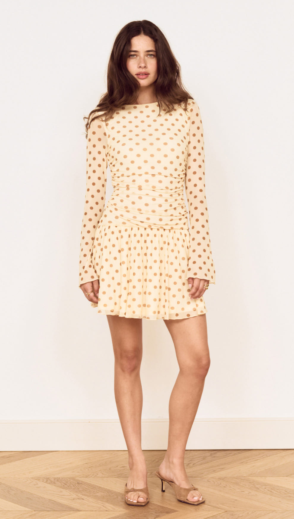 Butter Yellow Polka Dot Mini Dress with Drop Waist worn by a model, showcasing playful polka dots and a flared skirt.