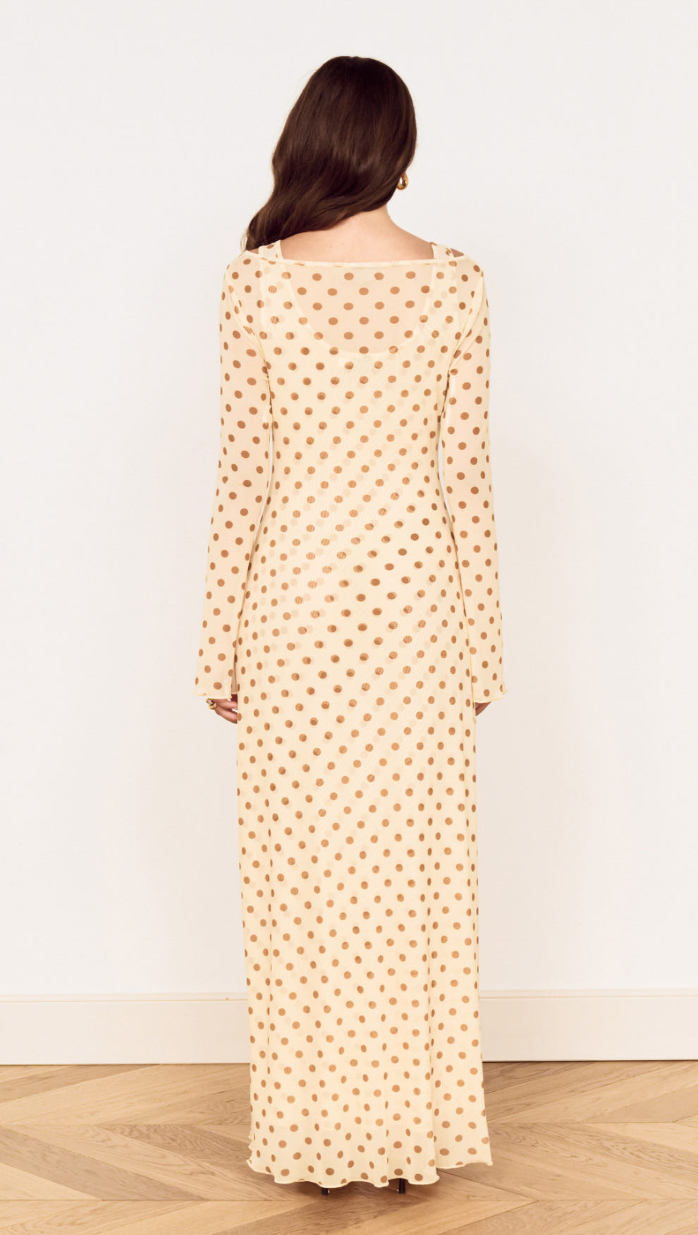 Back view of the Butter Yellow Polka Dot Midi Dress showcasing its layered design and flared sleeves.