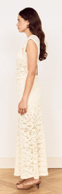 Side view of a woman wearing a Cream Cotton Lace Maxi Skirt paired with a matching lace top.