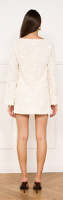 Sash Detail Sequin Mini Skirt in Cream worn from the back, featuring a fitted silhouette and draped sash.