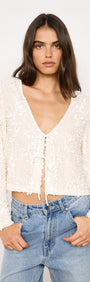 Model wearing Flute Sleeve Sequin Tie Blouse in Cream with a plunging neckline and tie-front fastening.