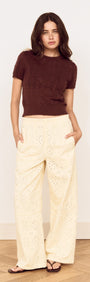 Model wearing a Brown Scallop Edge Knitted Tee with cream wide-leg pants, showcasing a chic and casual outfit.