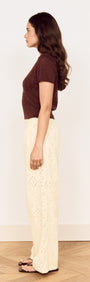Model wearing the Brown Scallop Edge Knitted Tee styled with beige wide-leg pants, showcasing a side view.