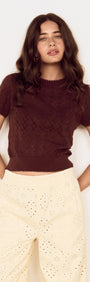 Brown Scallop Edge Knitted Tee featuring scalloped edges and short sleeves, styled with cream-colored pants.