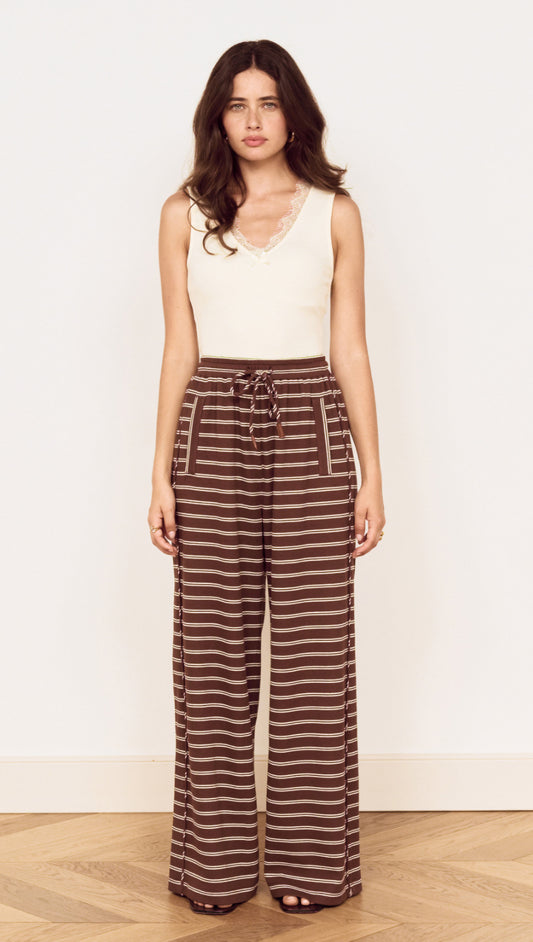 Model wearing Stripe Relaxed Drawstring Jersey Pant with a soft stretch fabric and vintage chocolate stripe design.