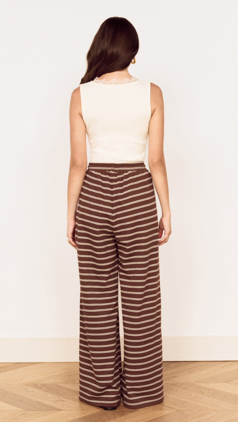Model wearing Stripe Relaxed Drawstring Jersey Pant with a vintage chocolate stripe design from the back.
