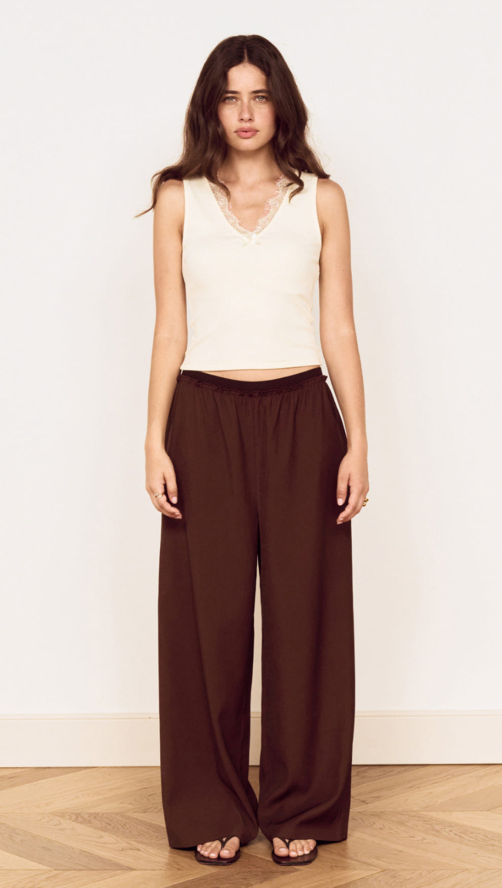 Model wearing a Cream Cotton Blend Tank with Lace Trim and brown wide-leg pants.