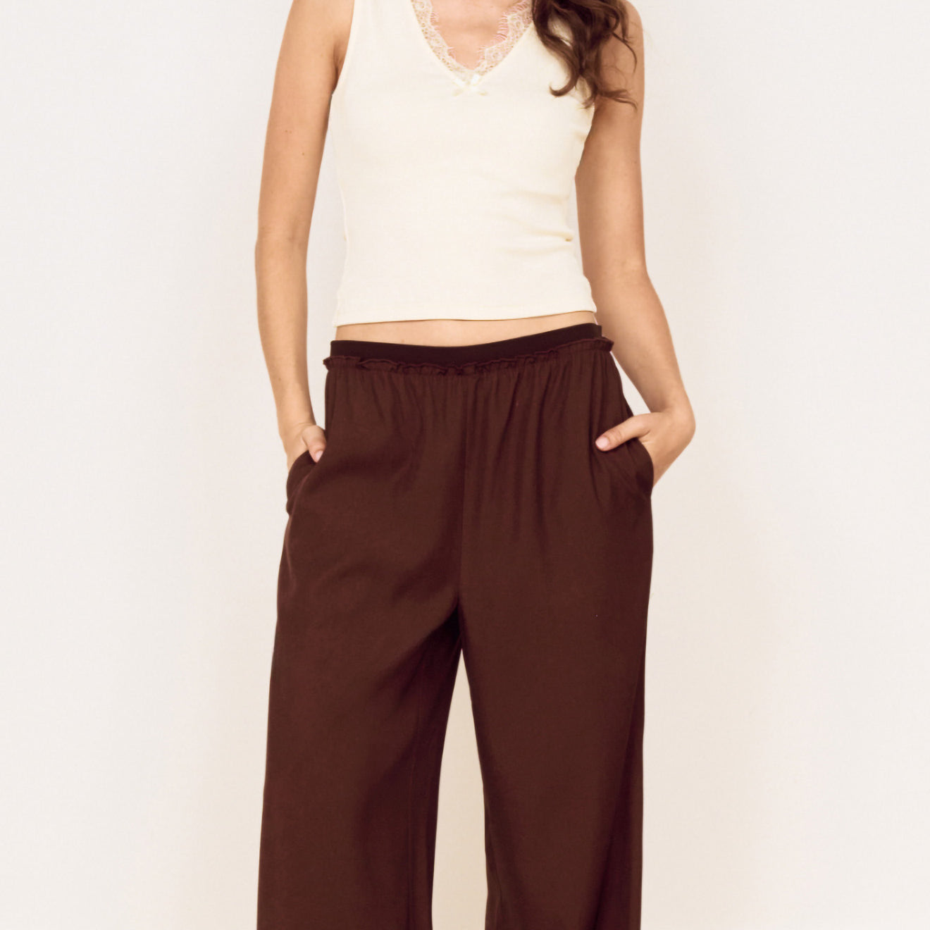 Model wearing a Cream Cotton Blend Tank with Lace Trim paired with relaxed brown pants, showcasing a stylish everyday outfit.