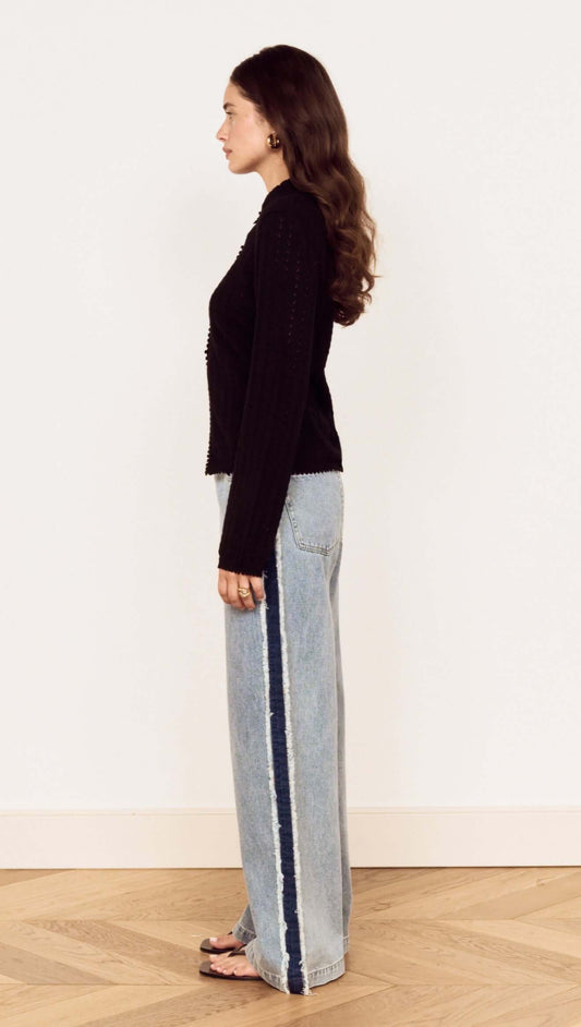 Model showcasing the Black Scallop Edge Pointelle Cardigan paired with wide-leg jeans, highlighting its fitted silhouette.