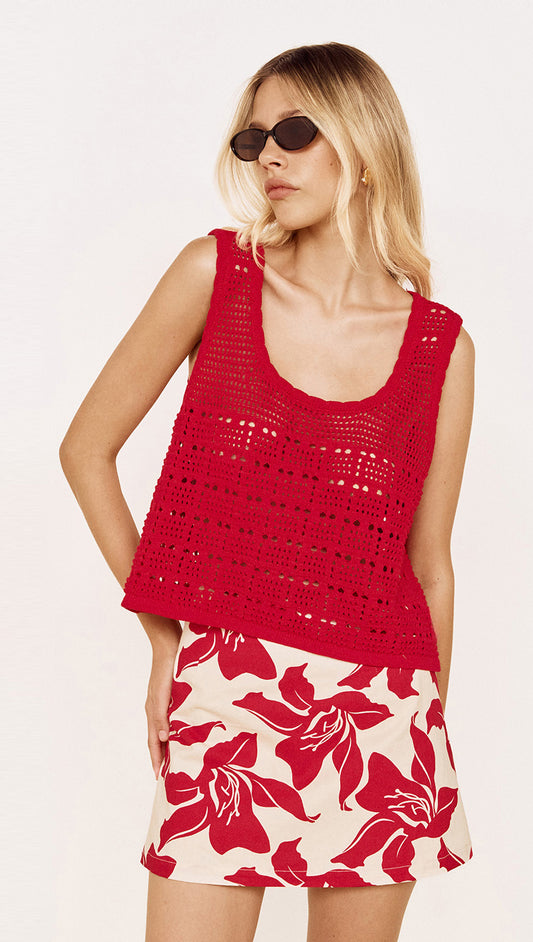 Model wearing a Round Neck Crochet Tank in Red paired with a floral skirt, showcasing a relaxed summer outfit.