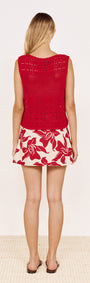 Back view of a woman wearing a Round Neck Crochet Tank in Red paired with a floral patterned skirt.