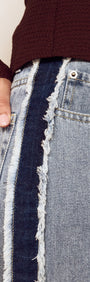 Close-up of Frayed Contrast Stripe Denim Jeans showcasing raw edge detailing and side panel contrast.