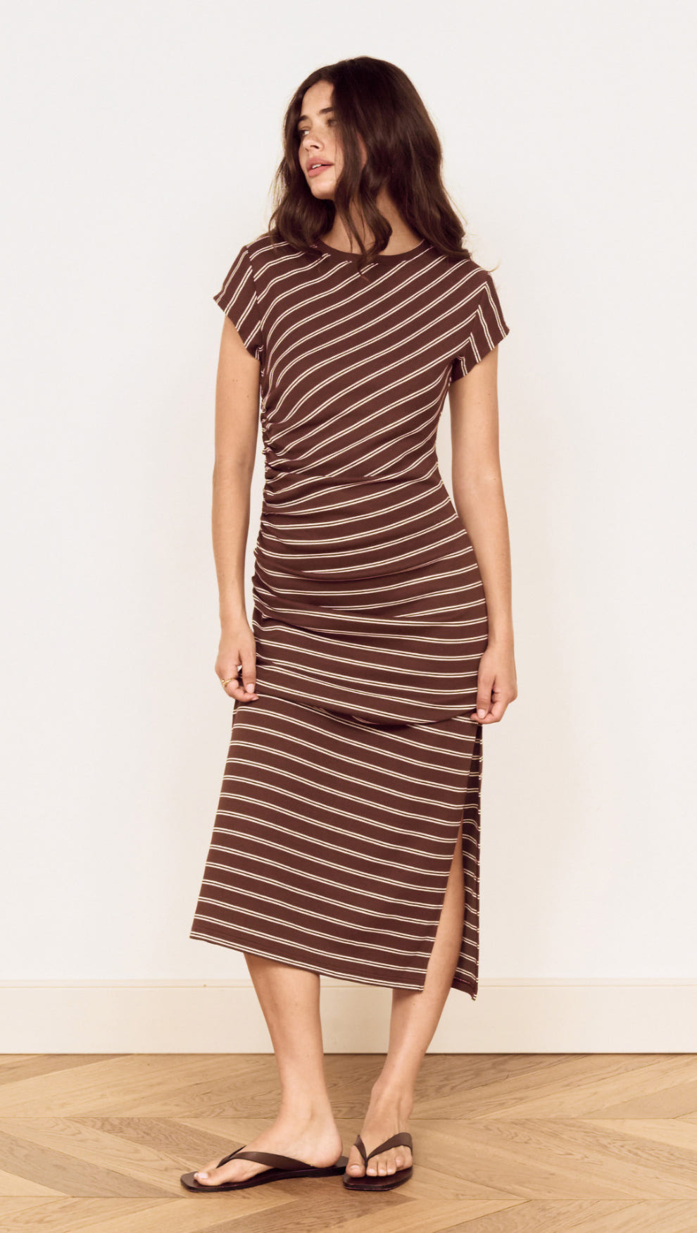 Model wearing a Striped Jersey Ruched Midi Dress with chocolate stripes and cap sleeves, showcasing stylish comfort.