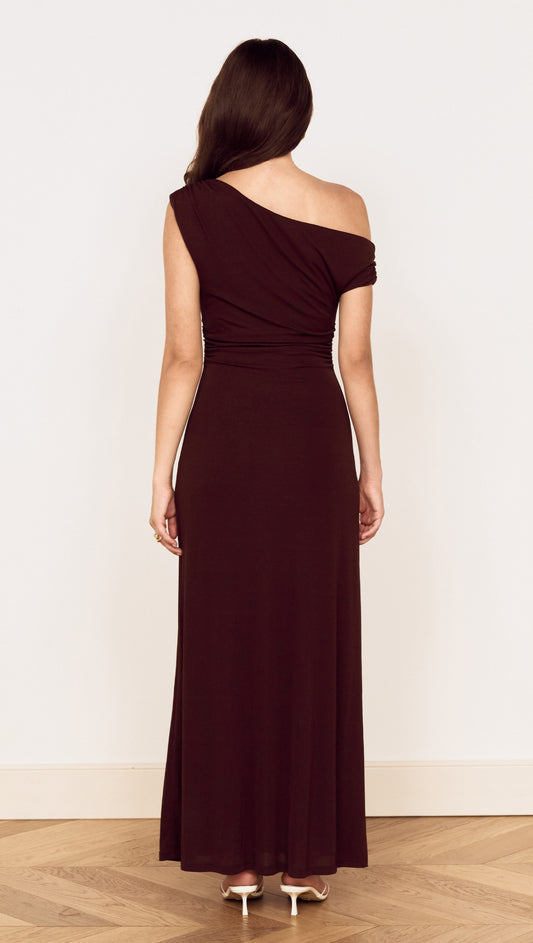 Rear view of a woman wearing a Chocolate One Shoulder Mesh Midi Dress with gathered detailing and fluid silhouette.