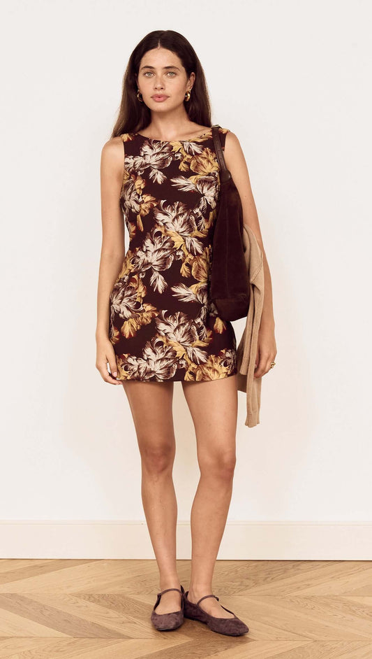 Model wearing a Brown Floral Tie Back Shift Dress with floral print and sleeveless design, complemented by a bag.