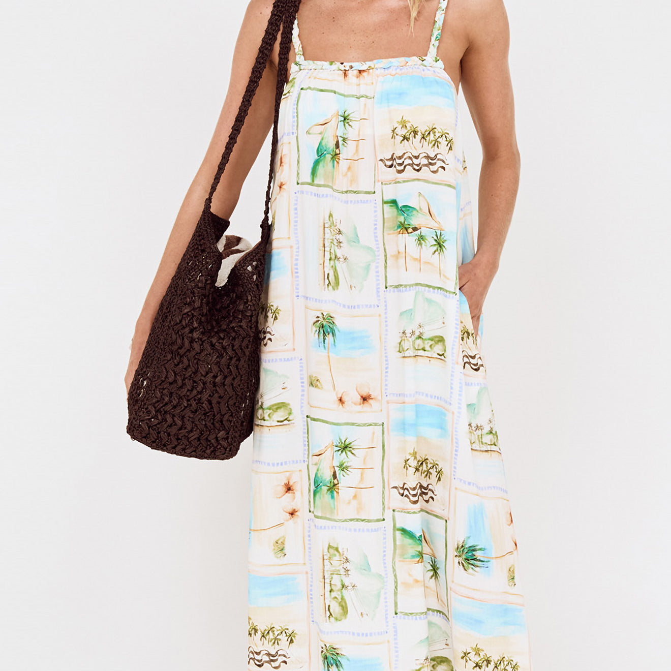 Model wearing Island Postcard Print Maxi Dress with Braided Straps, showcasing postcard-inspired print and braided shoulder straps.