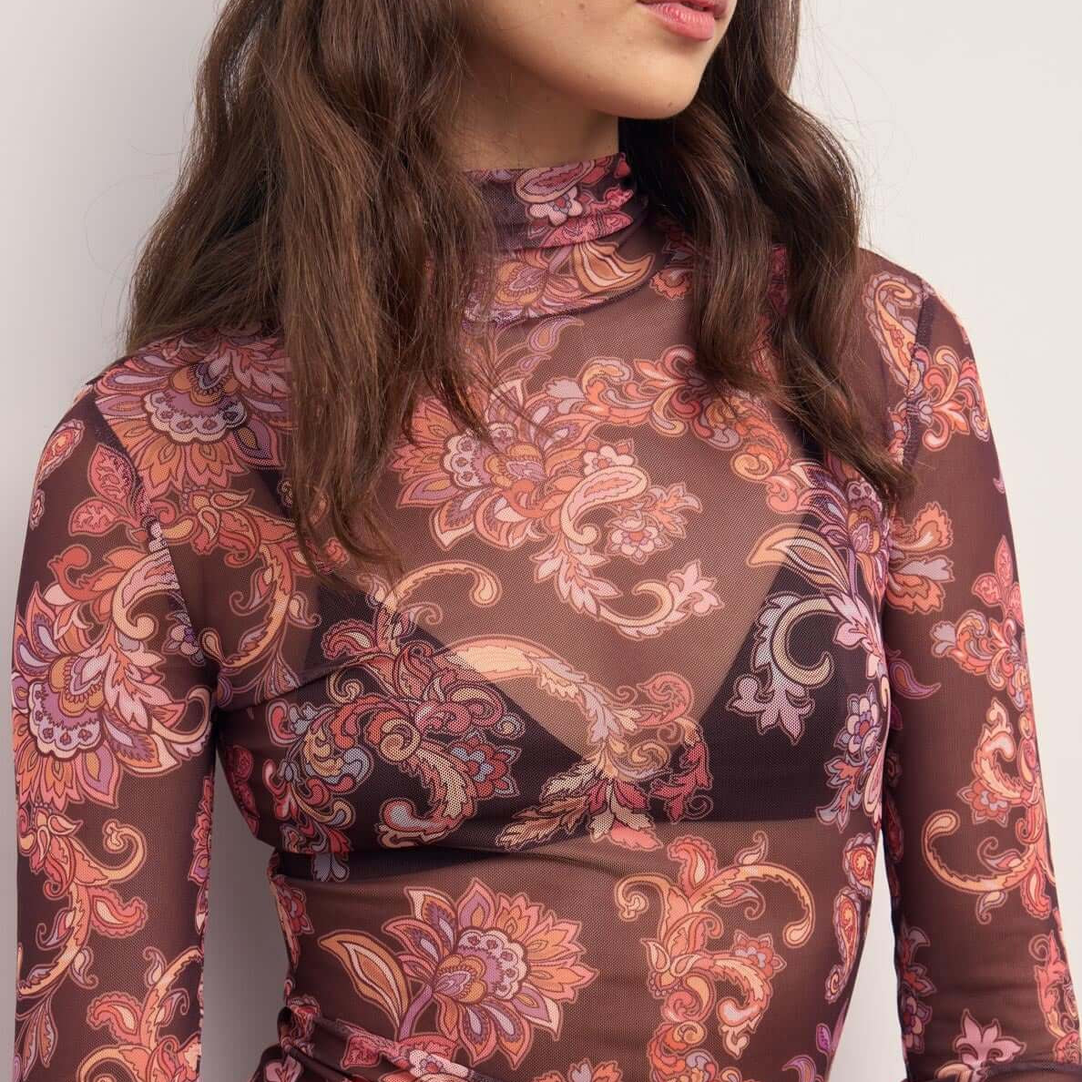 Sheer Printed Long Sleeve Mesh Top in floral print featuring a fitted silhouette and high neckline.