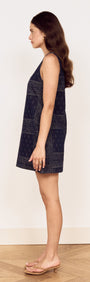 Side view of a model wearing the Paisley Jacquard Denim Mini Dress showcasing its A-line silhouette and scoop neckline.