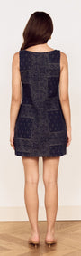 Back view of a woman wearing a Paisley Jacquard Denim Mini Dress, showcasing its intricate bandana-style motif.