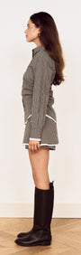 Model wearing Contrast Hem Mini Skirt in Grey Check with a matching shirt and knee-high boots.