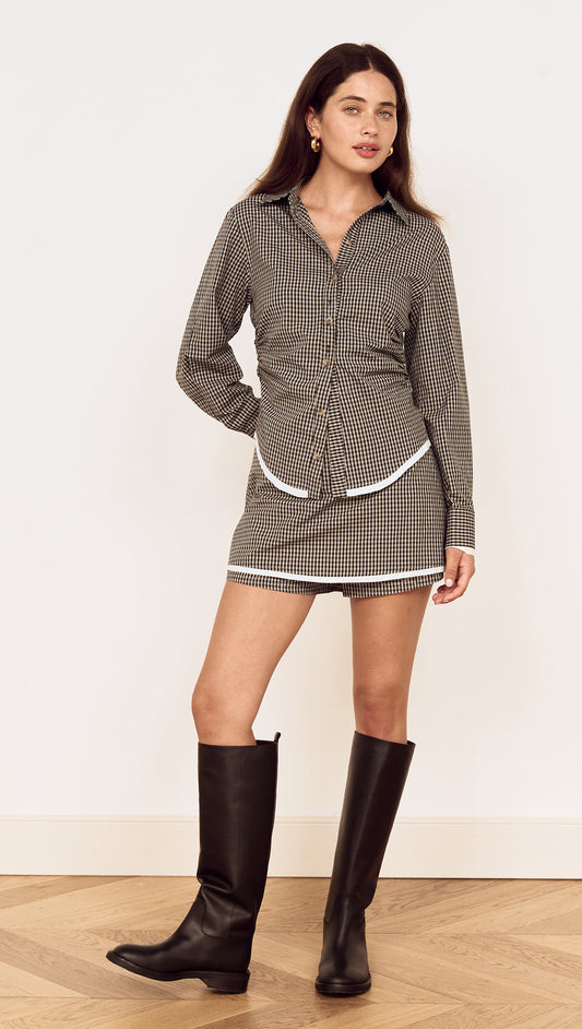 Model wearing the Contrast Hem Mini Skirt in Grey Check paired with a matching check shirt and knee-high boots.