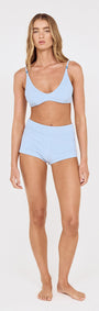 Model wearing textured swim shorts in sky blue and matching bikini top, ideal for beach days and poolside events.