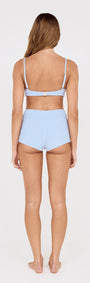 Back view of a model wearing Textured Swim Shorts in Sky Blue with a matching top.