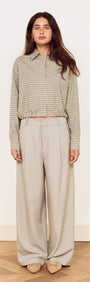 Model wearing Mid Rise Tailored Suit Pant in Grey paired with a checkered blouse.