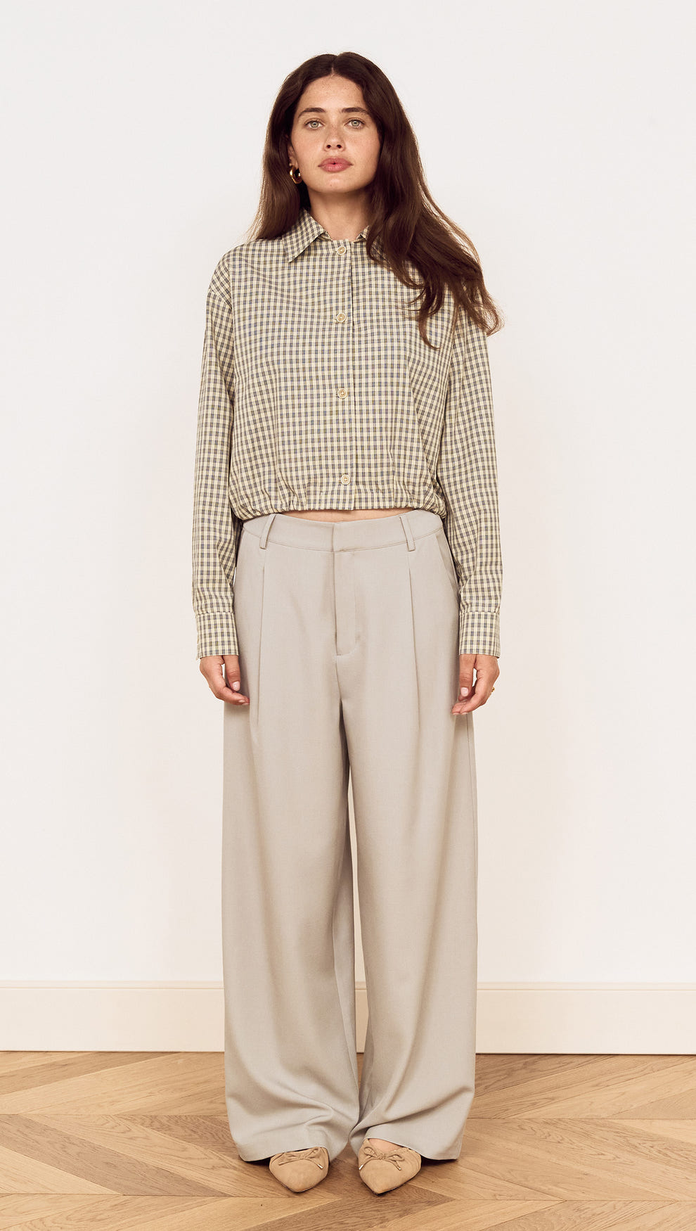 Model wearing Mid Rise Tailored Suit Pant in Grey paired with a checkered blouse.