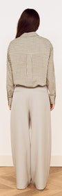 Cotton Bubble Hem Shirt in Blue Check viewed from the back, paired with wide leg trousers for a relaxed look.