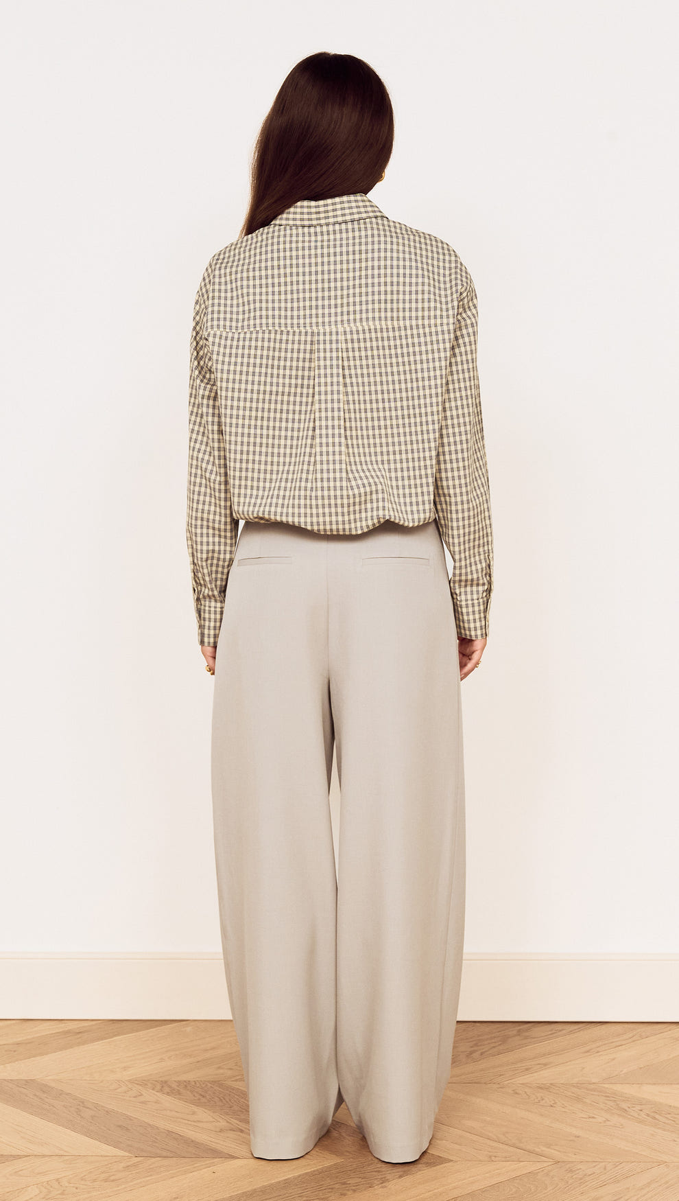 Cotton Bubble Hem Shirt in Blue Check viewed from the back, paired with wide leg trousers for a relaxed look.
