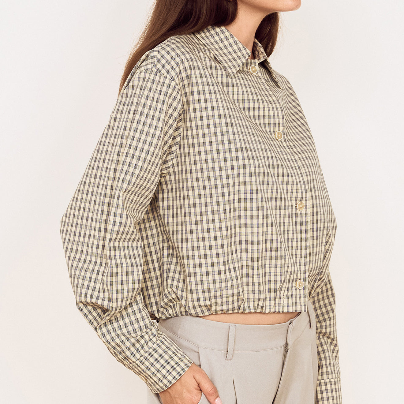 Cotton Bubble Hem Shirt in Blue Check worn with tailored pants, showing a side view and gathered bubble hem design.