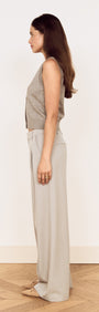 Round Neck Knitted Vest in Soft Grey worn with light trousers, showcasing a side view of the fitted silhouette.