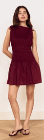 Model wearing a Cotton Shirred Mini Dress in Burgundy with a shirred bodice and gathered skirt.