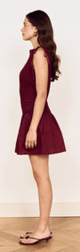 Cotton Shirred Mini Dress in Burgundy displayed on a model, highlighting its feminine silhouette and playful shoulder ties.