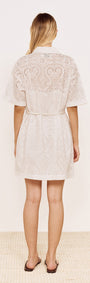 Back view of a woman wearing a Cotton Broderie Mini Shirtdress in White with a relaxed fit and belt.