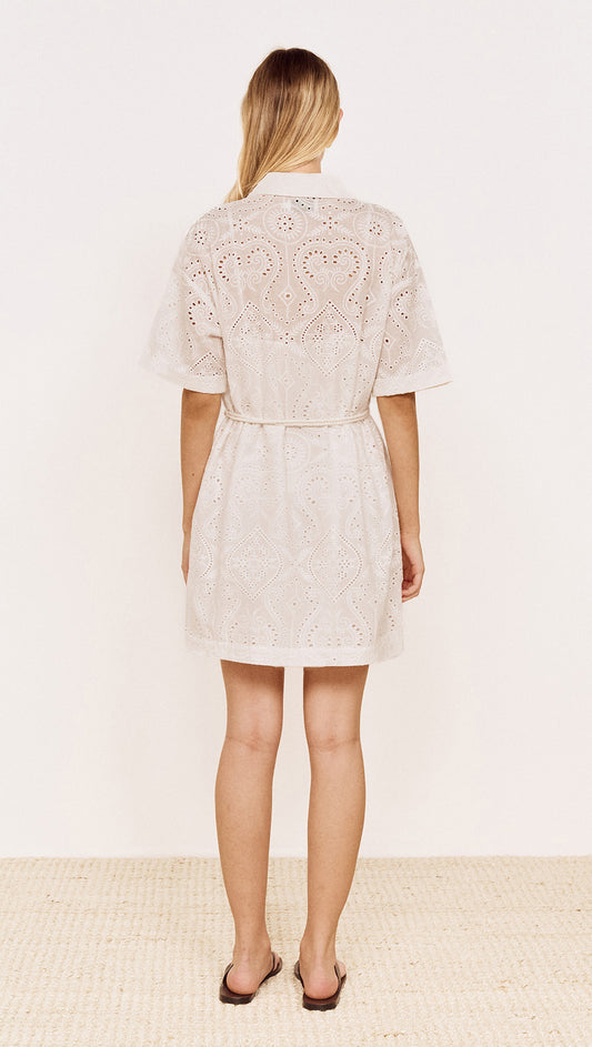Back view of a woman wearing a Cotton Broderie Mini Shirtdress in White with a relaxed fit and belt.