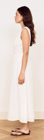 Side view of a model wearing a Cotton Broderie Anglaise Sleeveless Dress in white, showcasing its elegant silhouette.