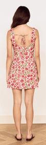 Back view of a woman wearing a Vintage Floral Print Tie-Back Mini Dress with a tie detail.