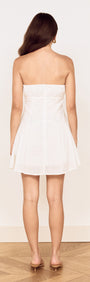 Back view of the White Cotton Broderie Mini Dress showcasing its flared skirt and strapless design.