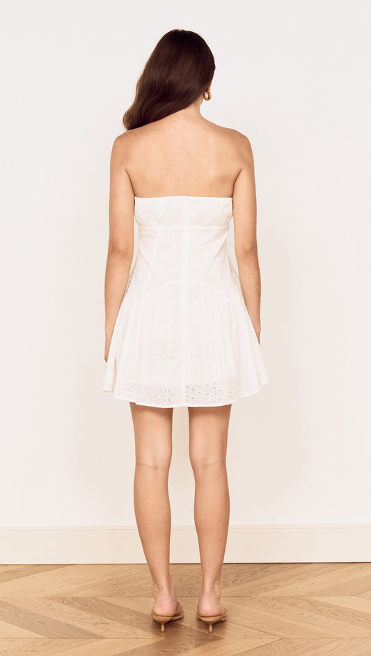 Back view of the White Cotton Broderie Mini Dress showcasing its flared skirt and strapless design.