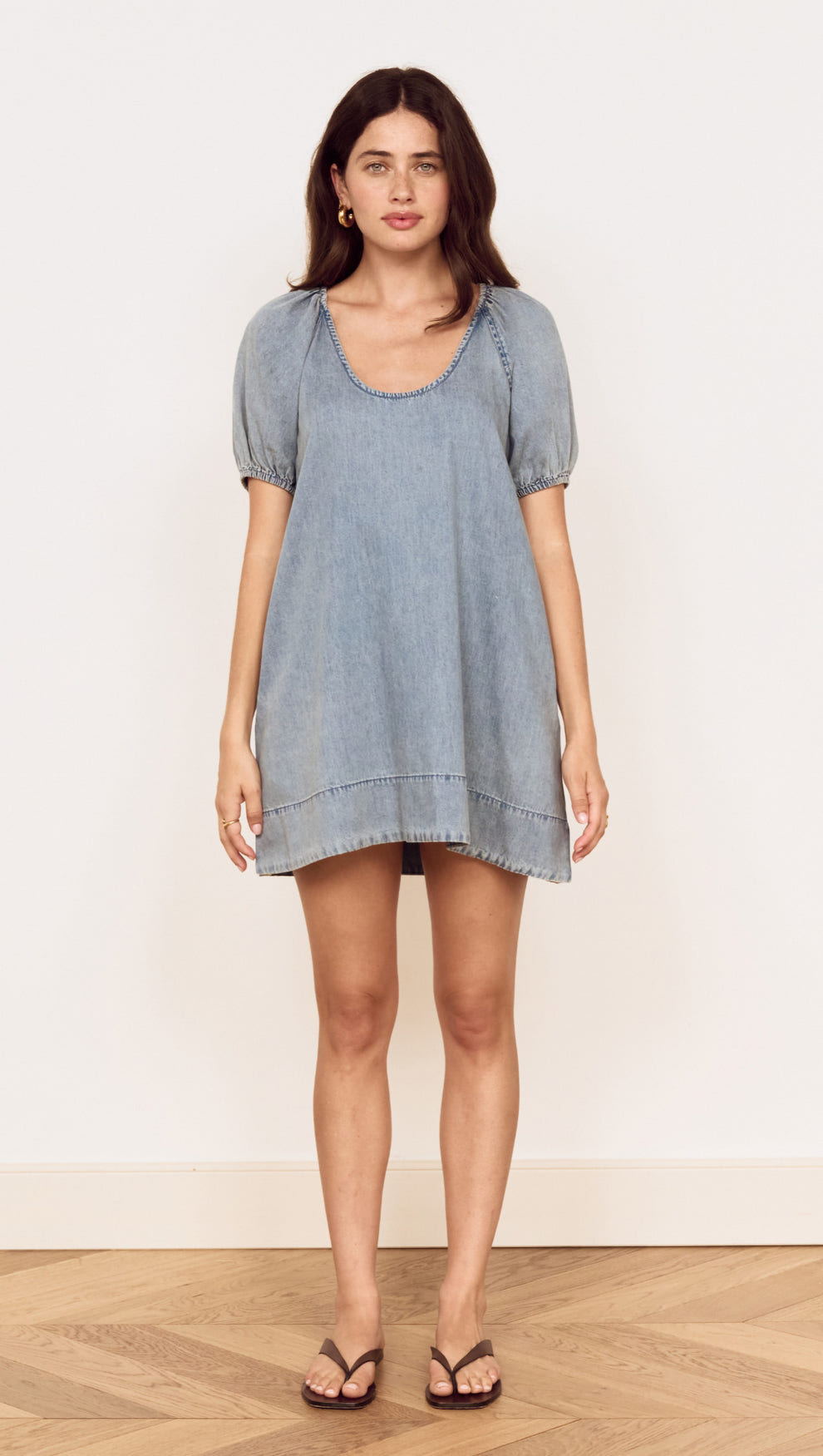 Model wearing Puff Sleeve Fluid Denim Mini Dress in soft washed denim with puff sleeves and scoop neckline.