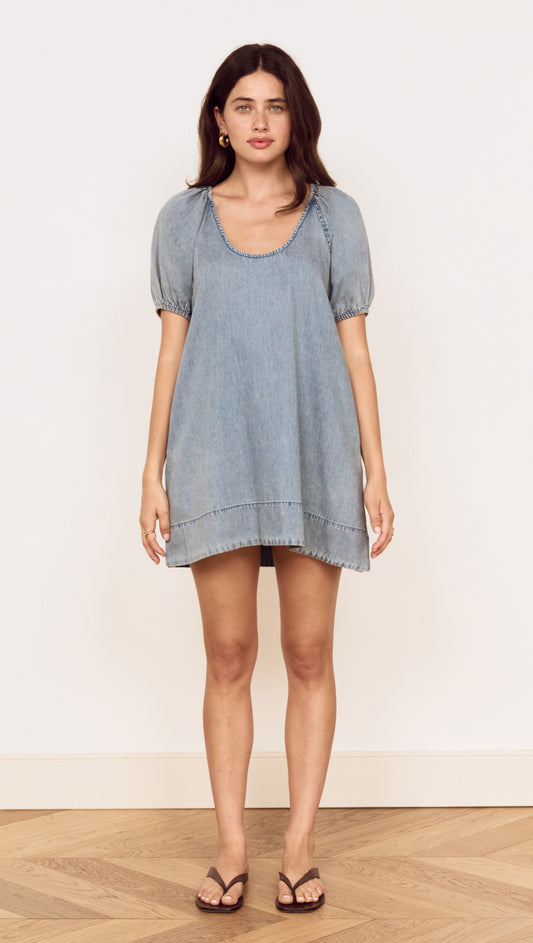 Model wearing Puff Sleeve Fluid Denim Mini Dress in soft washed denim with puff sleeves and scoop neckline.