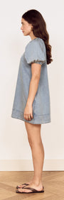 Model showcasing the Puff Sleeve Fluid Denim Mini Dress from the side, featuring a relaxed A-line silhouette.