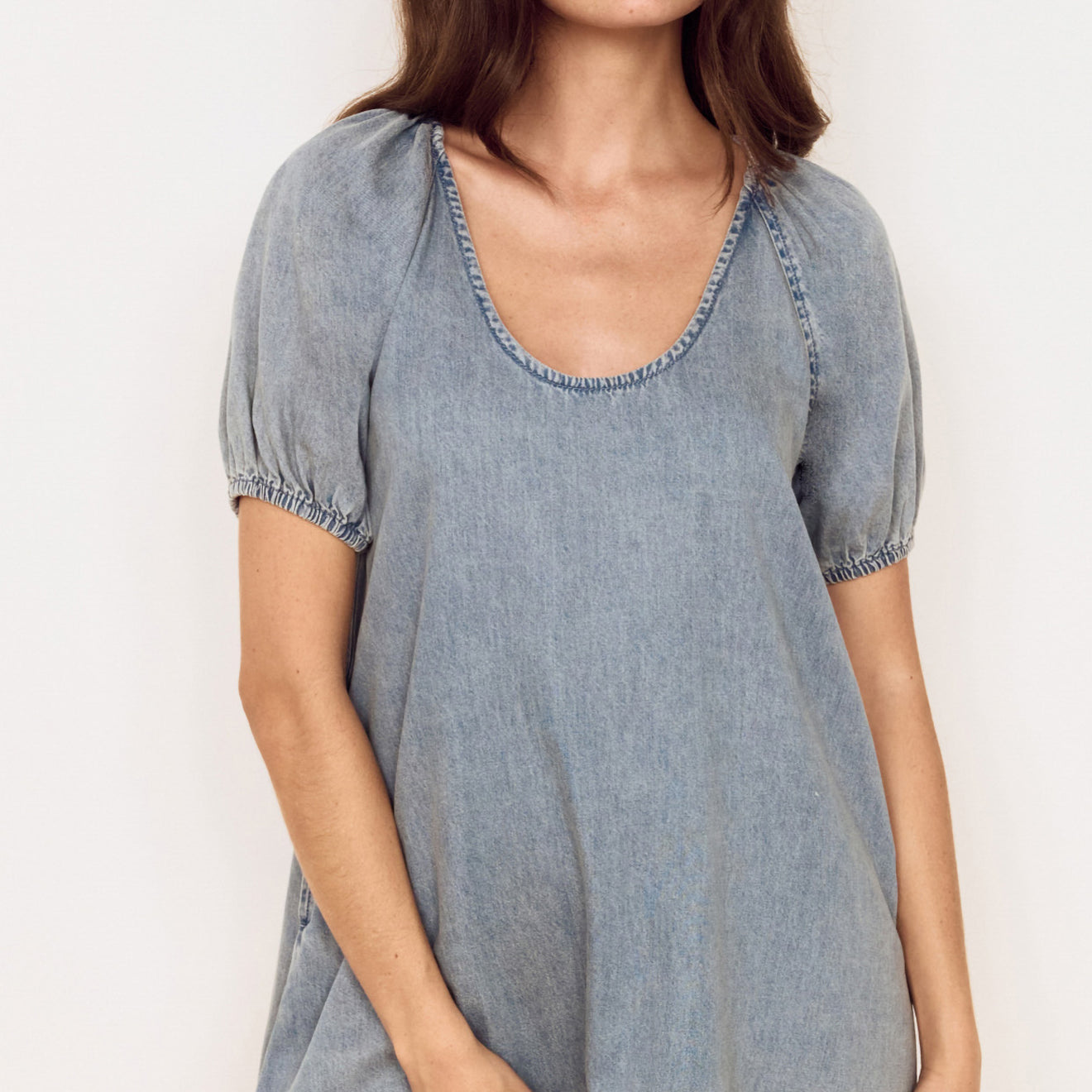Puff Sleeve Fluid Denim Mini Dress featuring puff sleeves and a relaxed silhouette in soft washed denim.