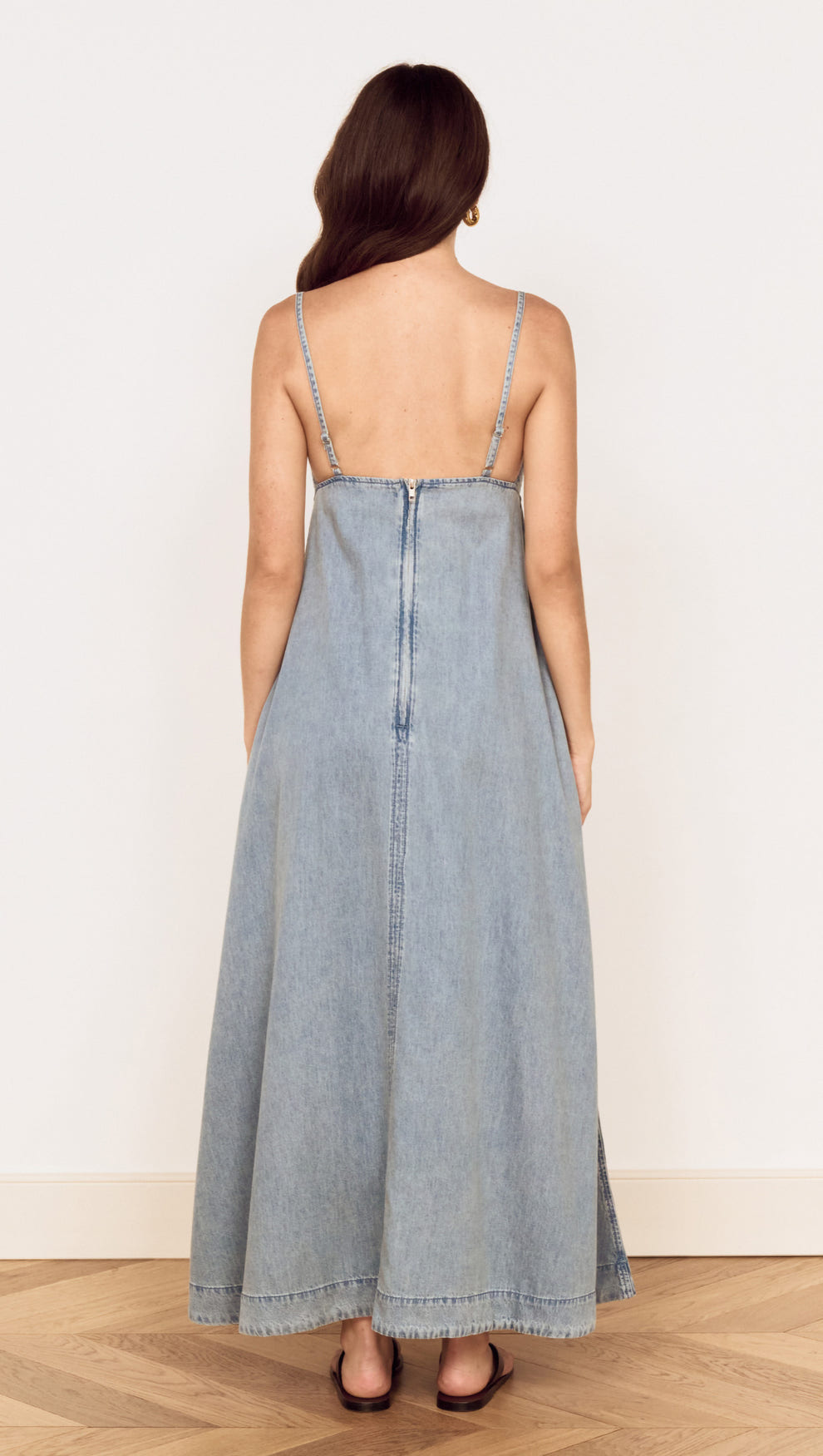 Back view of the Fluid Denim Maxi Sundress in Lightwash showcasing its flowing silhouette and delicate straps.
