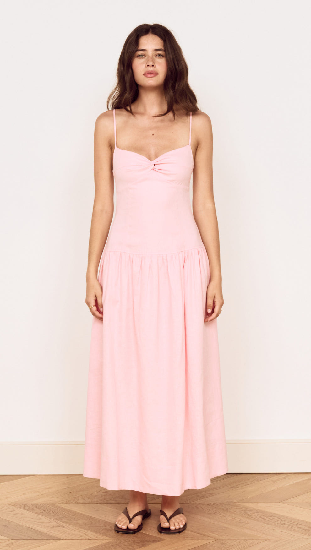Linen Blend Midi Dress with Drop Waist displayed on a model in soft pink hue with twist-front detail and adjustable straps.