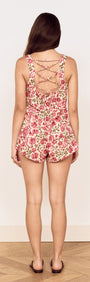 Back view of a model wearing Vintage Floral Print Mini Shorts with a crisscross strap design.
